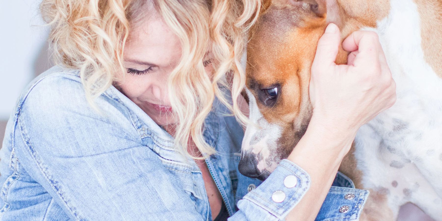 Mujer abrazando a su perro con cariño